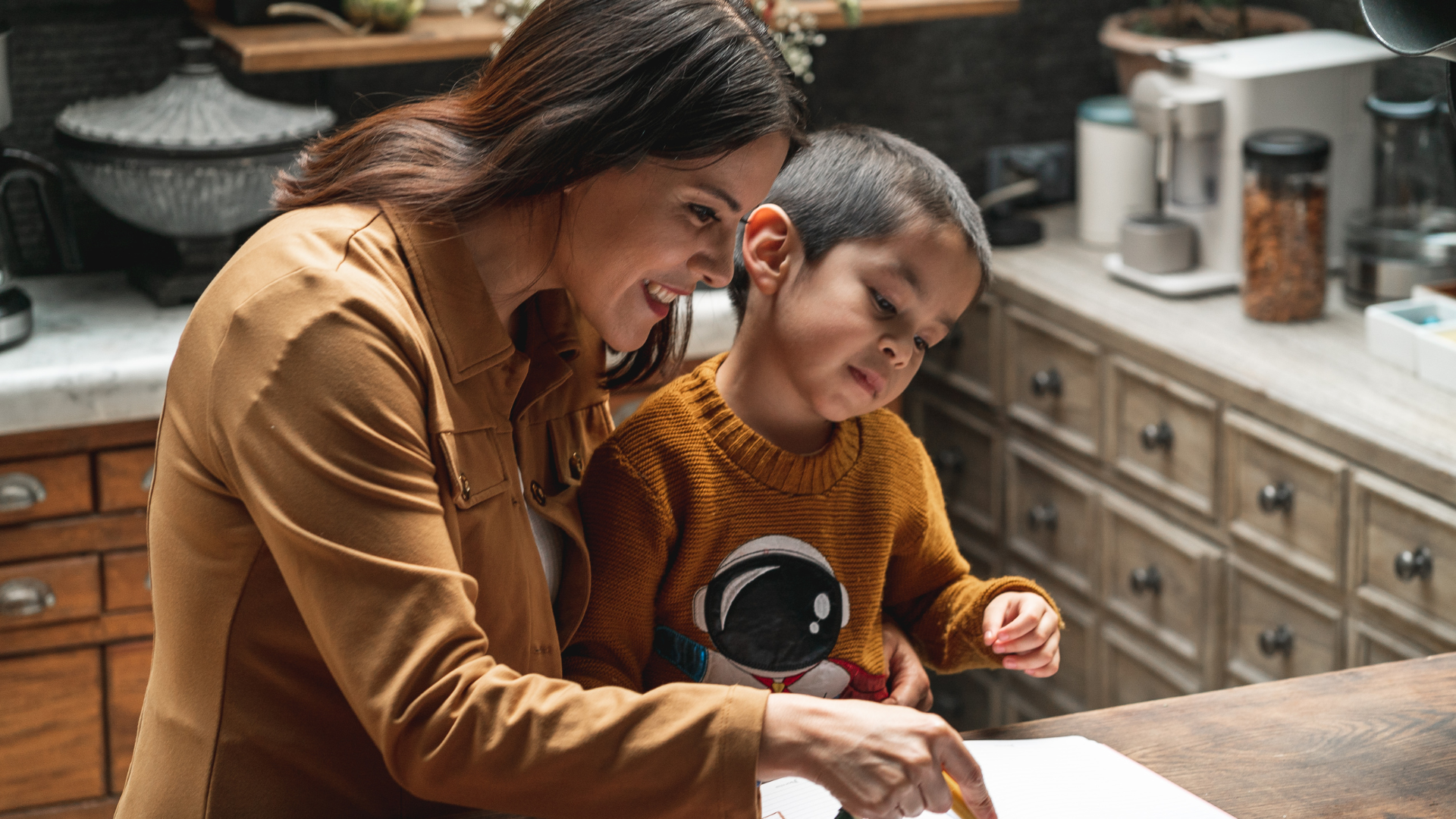 A woman and a child are preparing food in a kitchen.