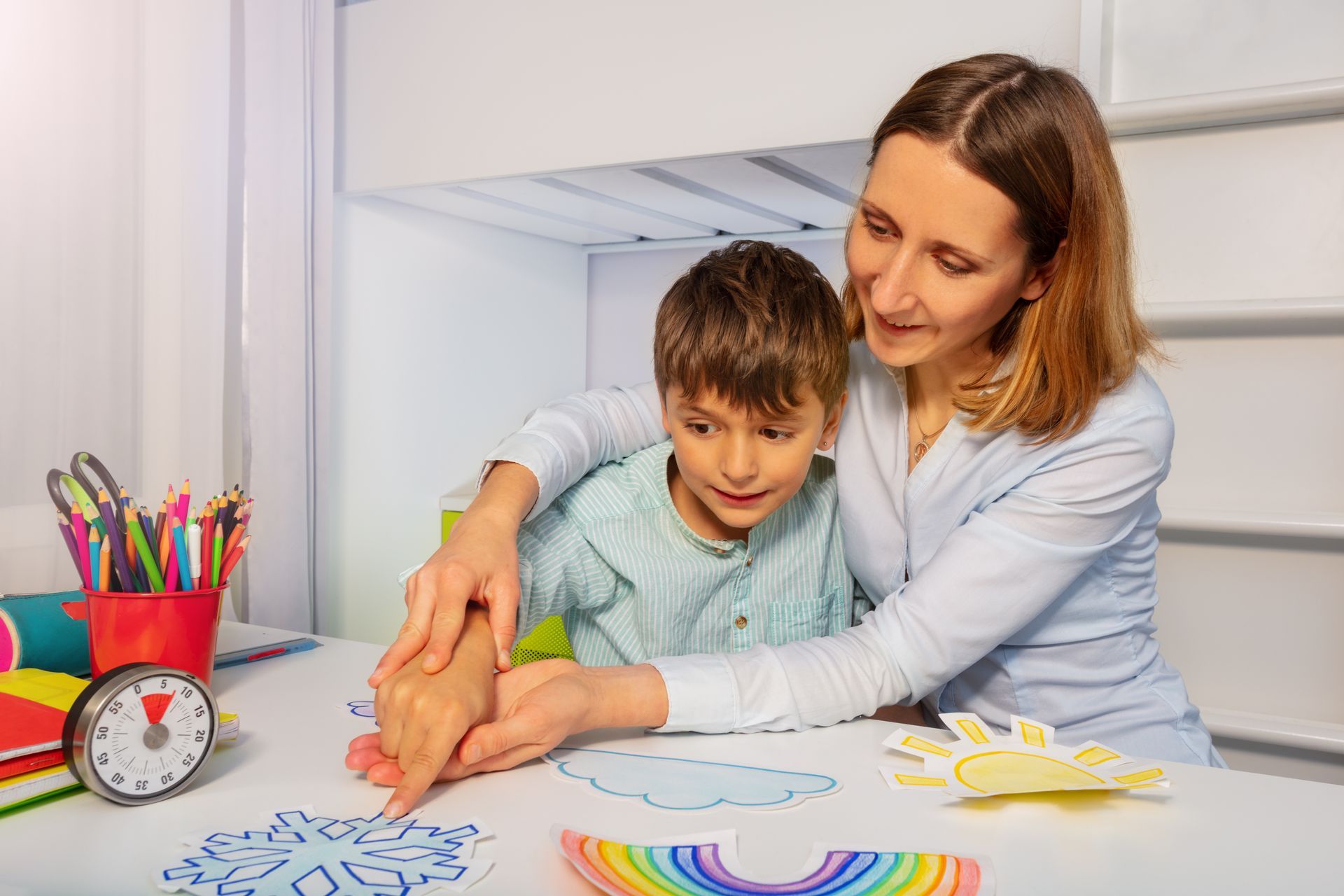 A woman is sitting at a table with a child.