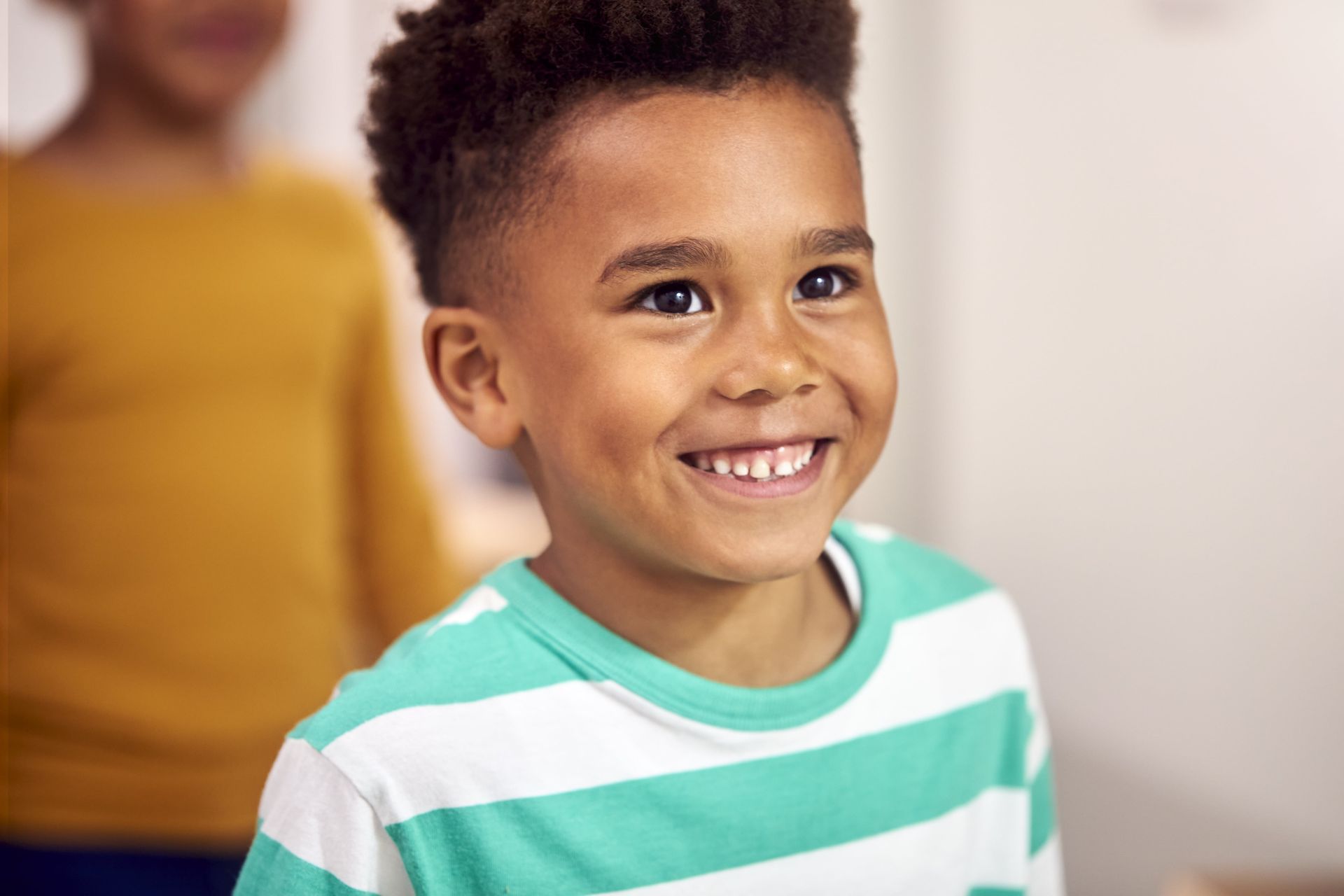 A little girl wearing glasses and a pink shirt is smiling