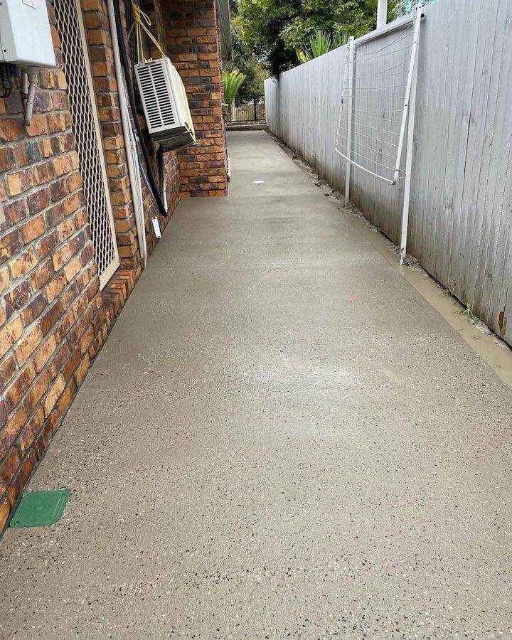 A brick building with a concrete walkway leading to it.