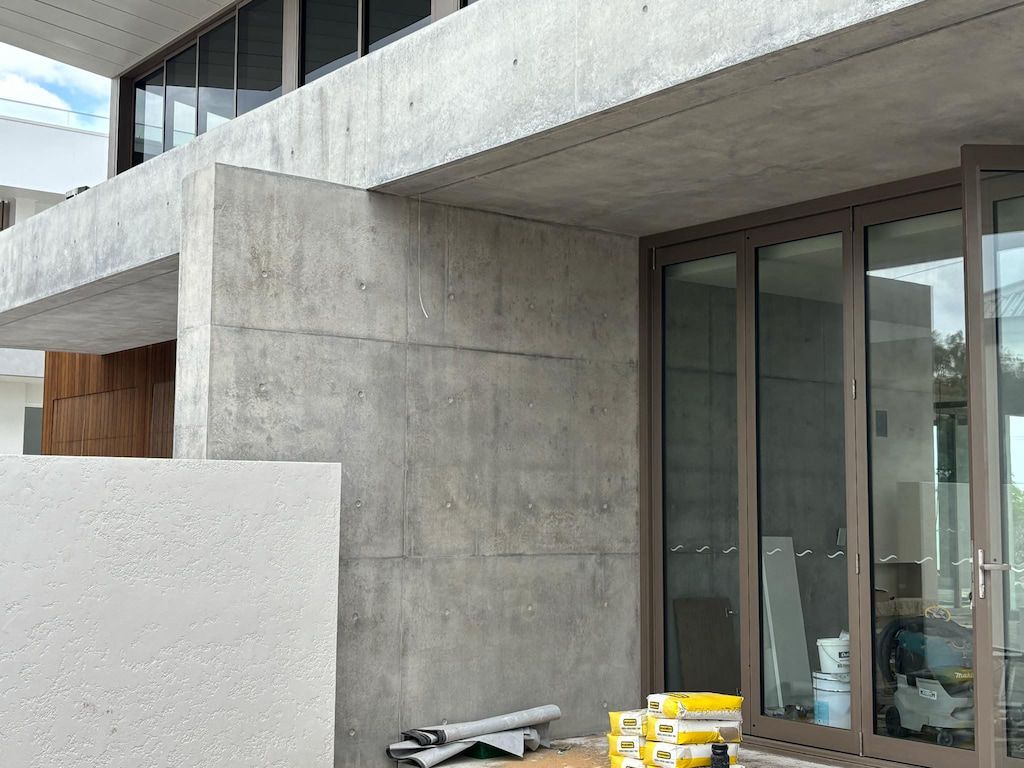 A building under construction with a lot of windows and a concrete wall.