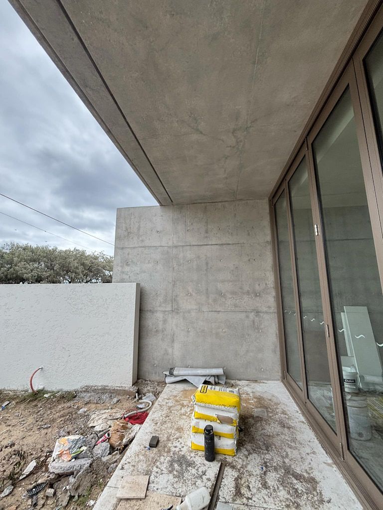 A building under construction with a lot of windows and a concrete wall.