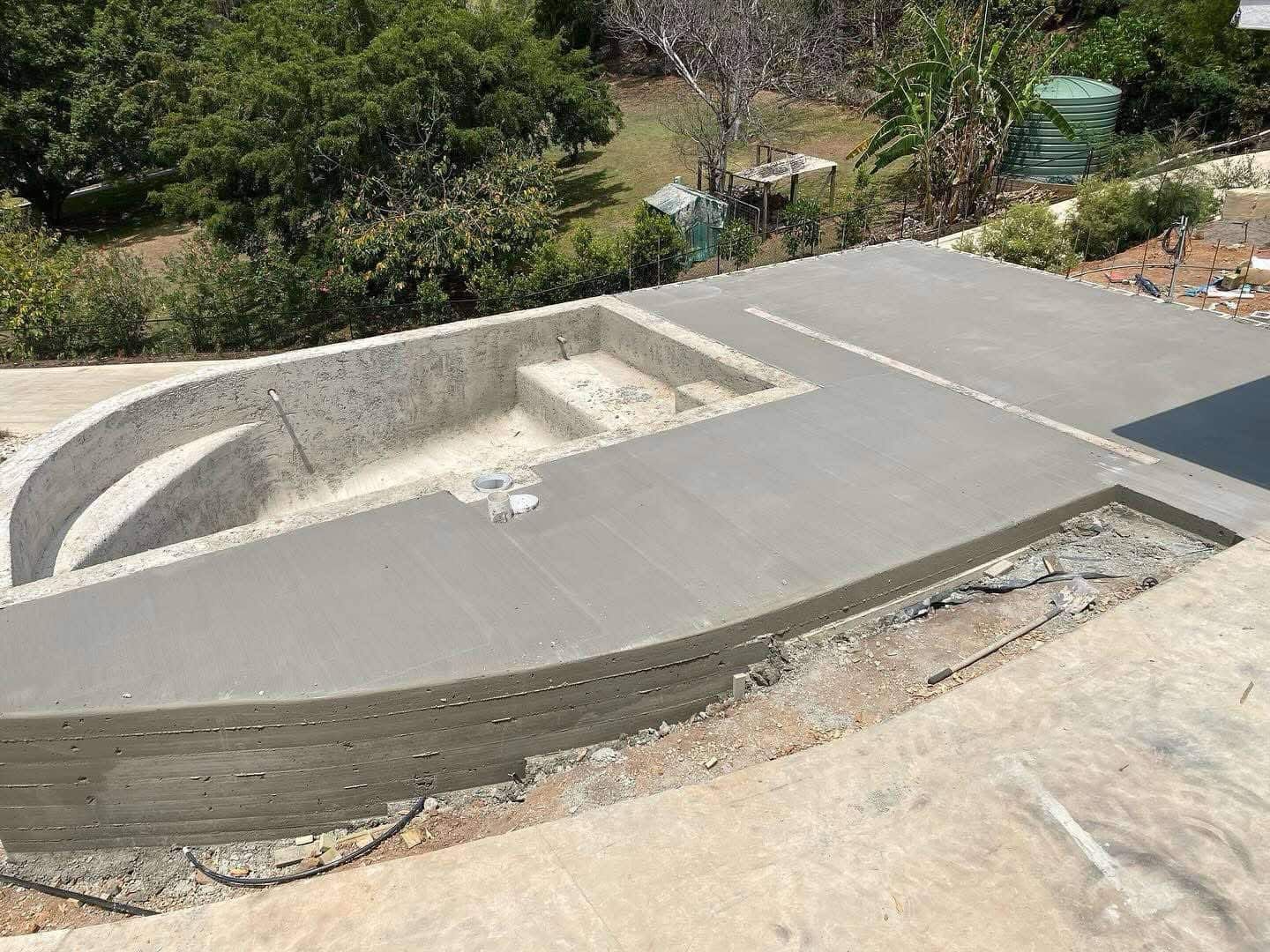 A large concrete pool is being built on top of a hill.