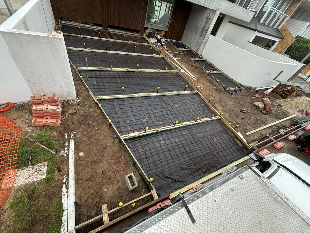 An aerial view of a concrete driveway being built in front of a Sunshine Coast house.