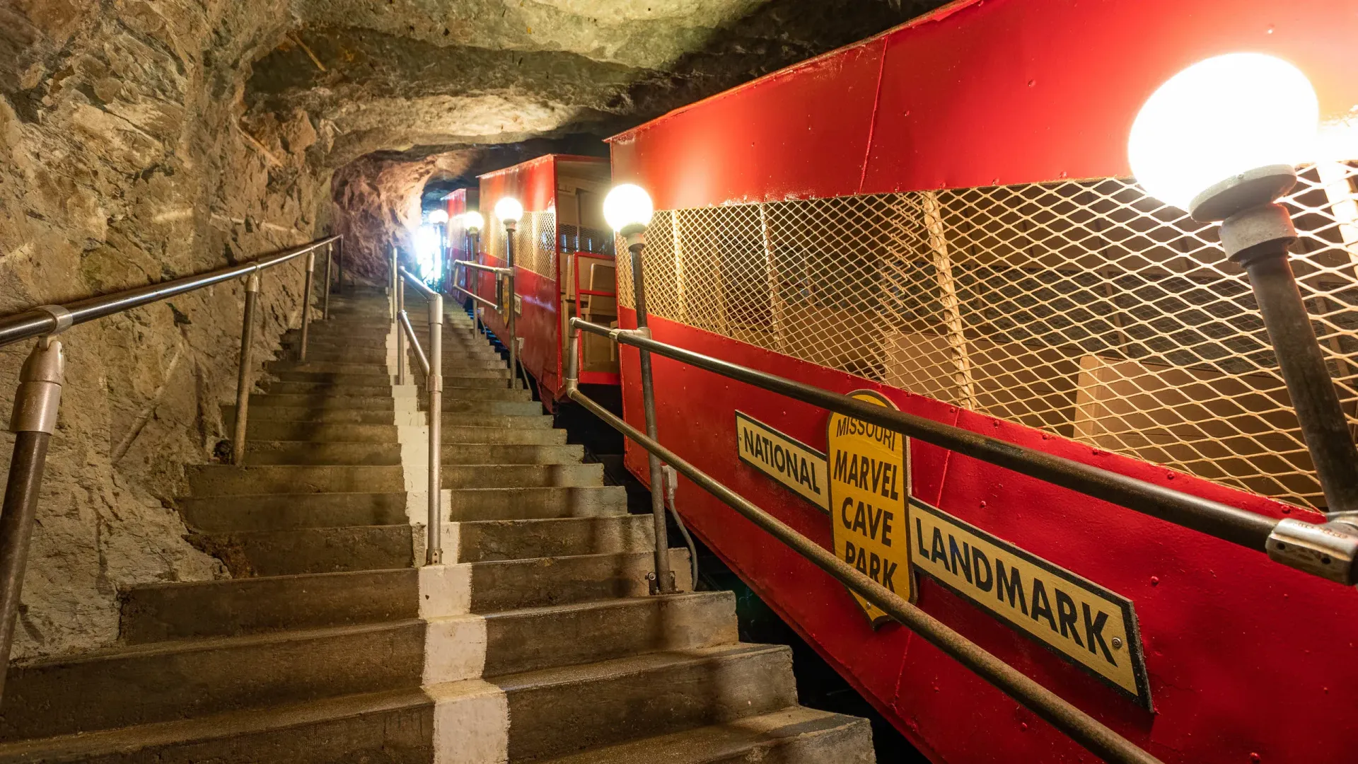 Staircase in cave with red tram.