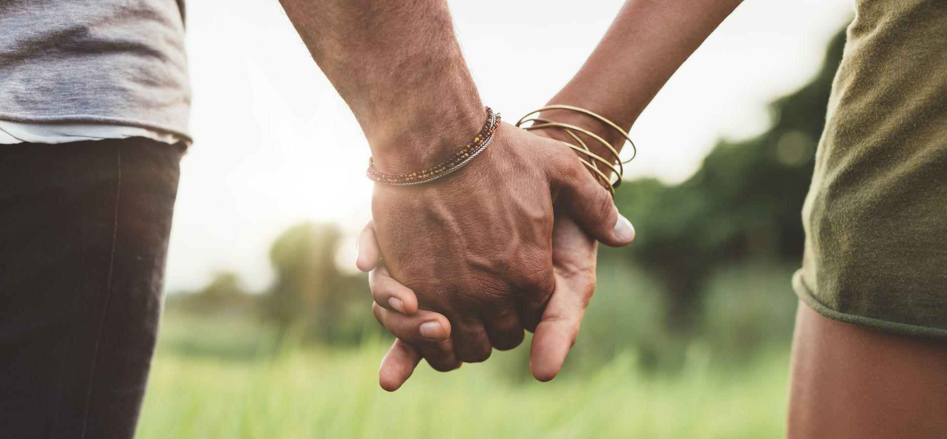 A man and a woman are holding hands in a field.