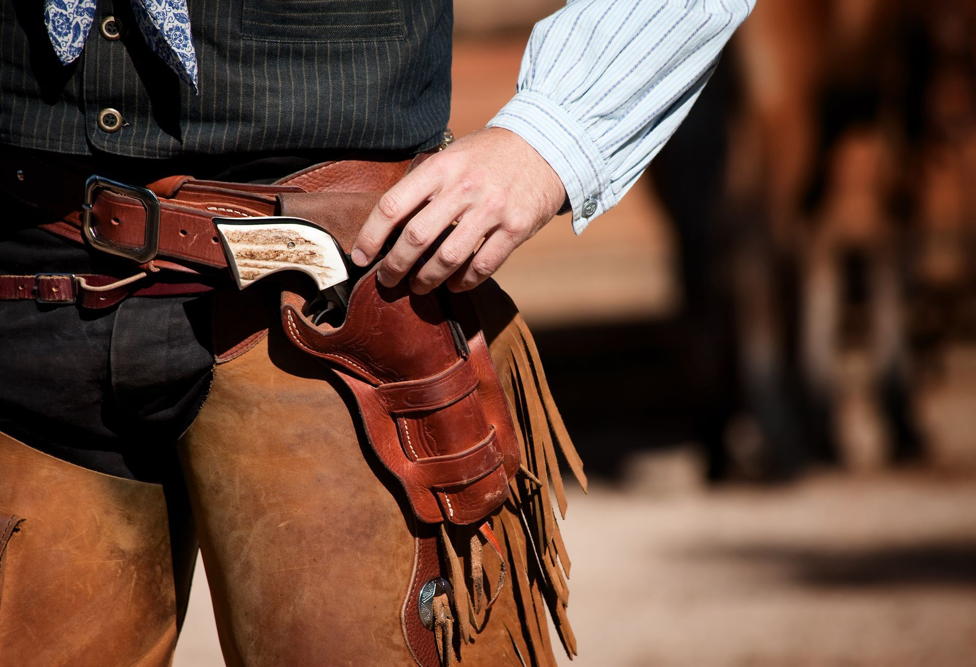 A cowboy with a gun and holster on his hip