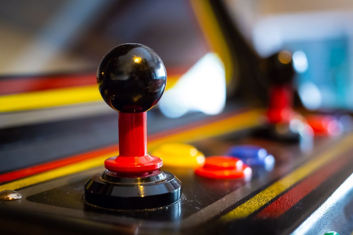 A close up of a video game controller on an arcade machine.