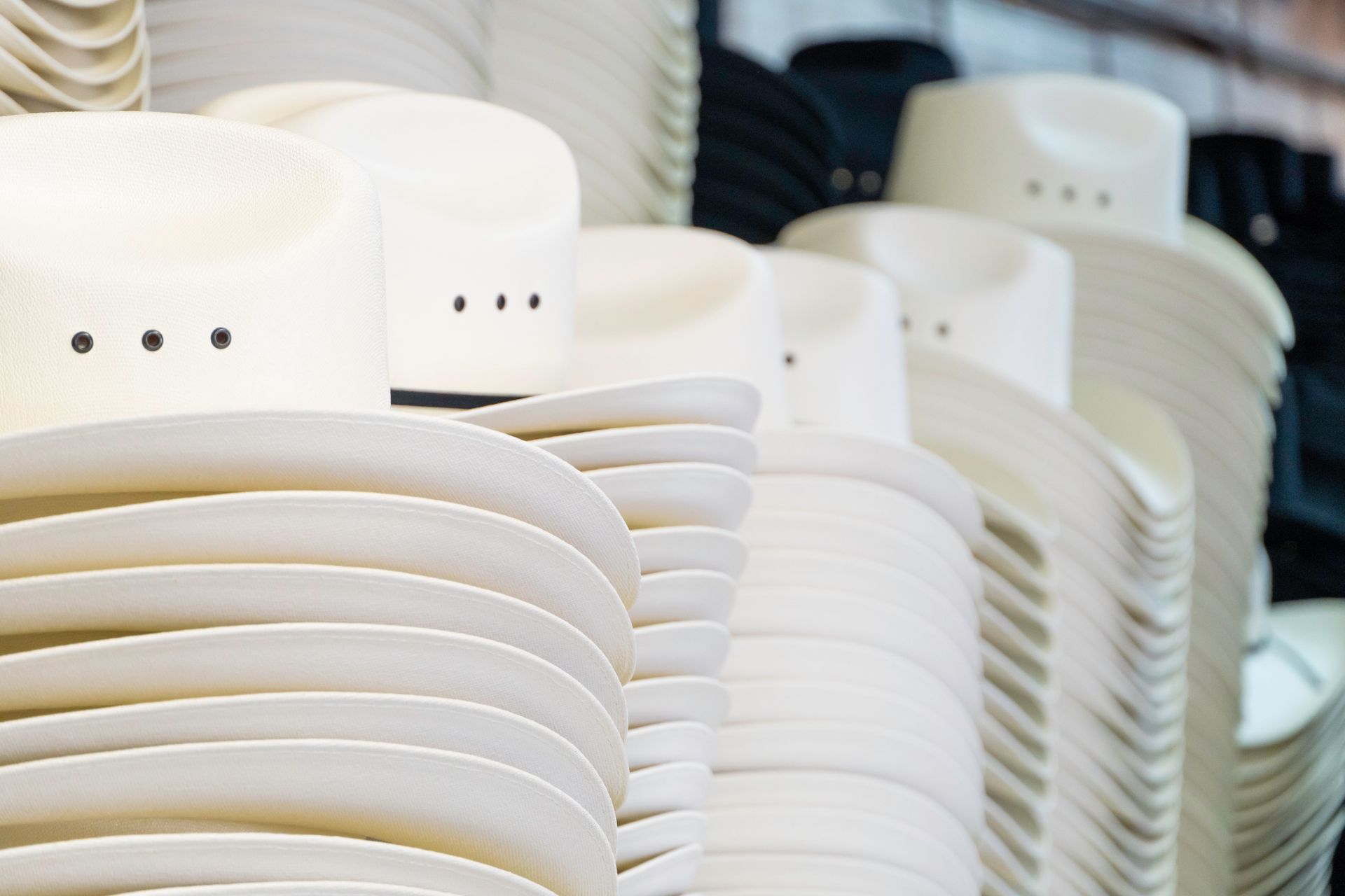 A row of cowboy hats are stacked on top of each other