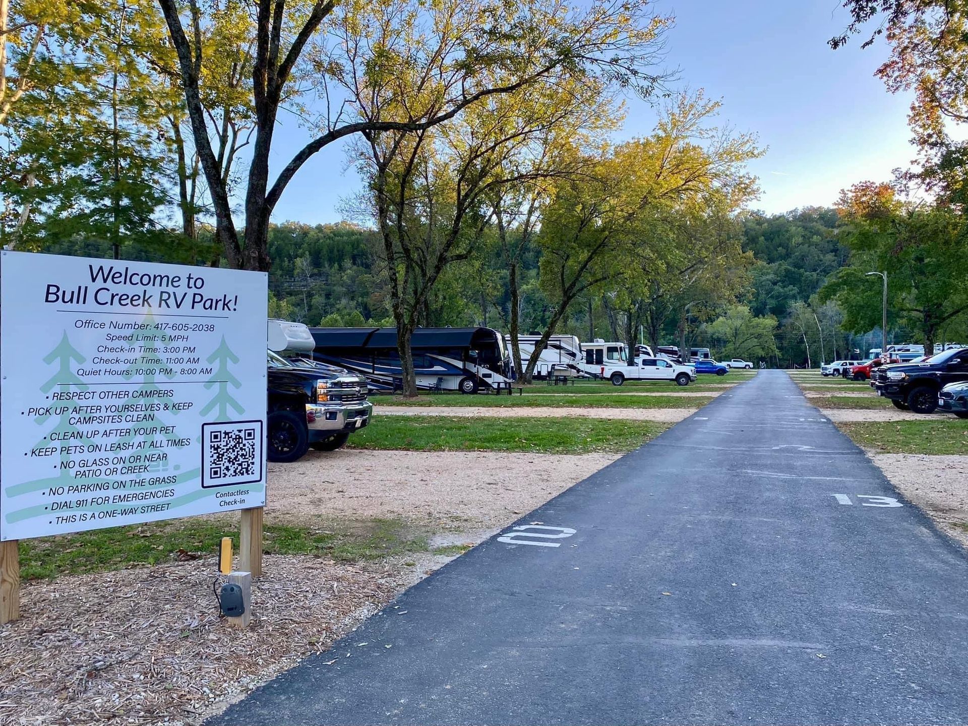 A sign that says welcome to boat creek rv park is on the side of a road.