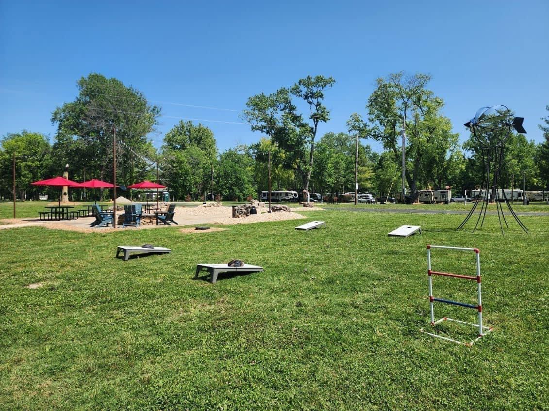 A park with a lot of grass and a ladder in the middle of it.