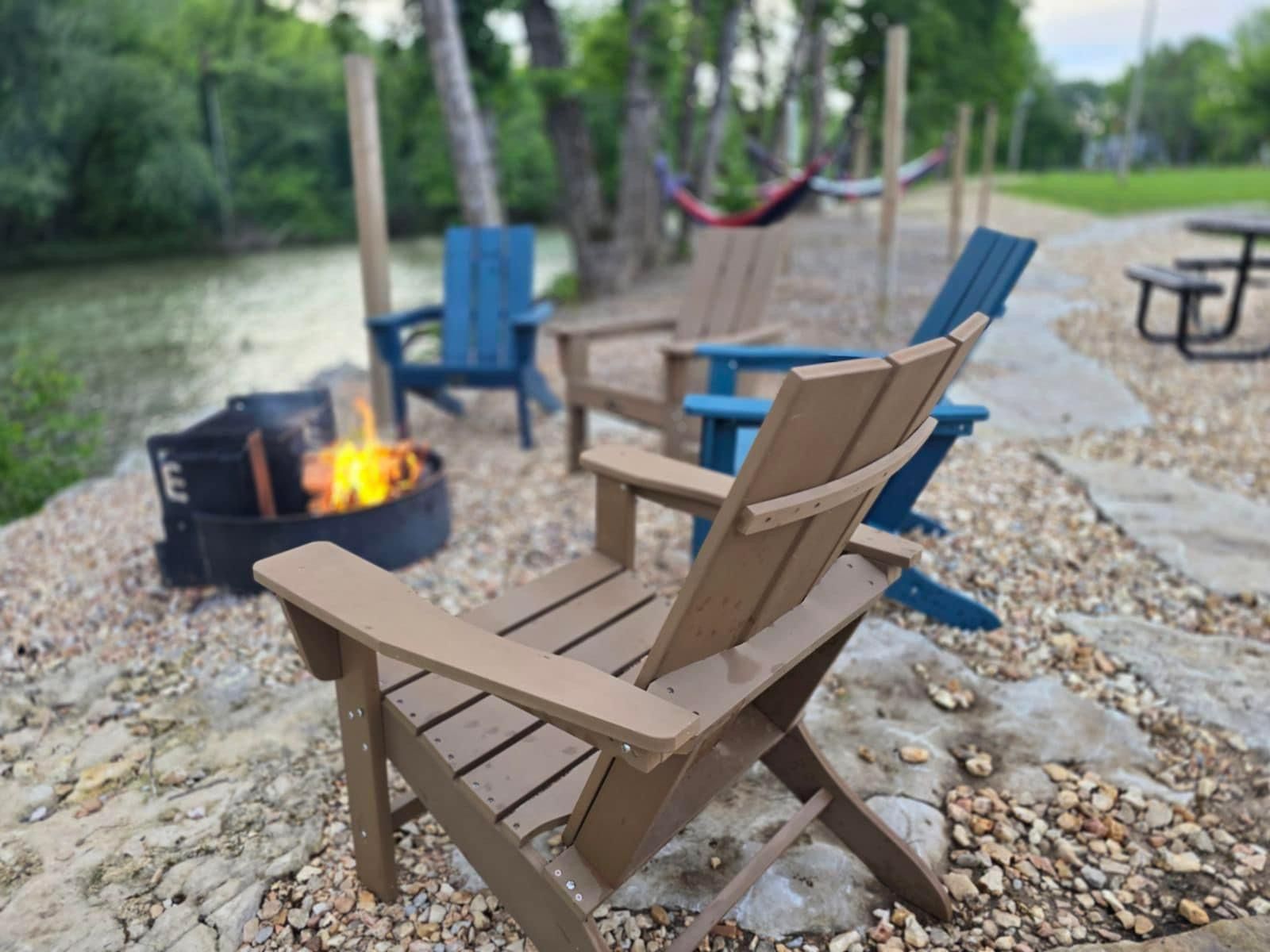 A group of chairs are sitting in front of a fire pit.