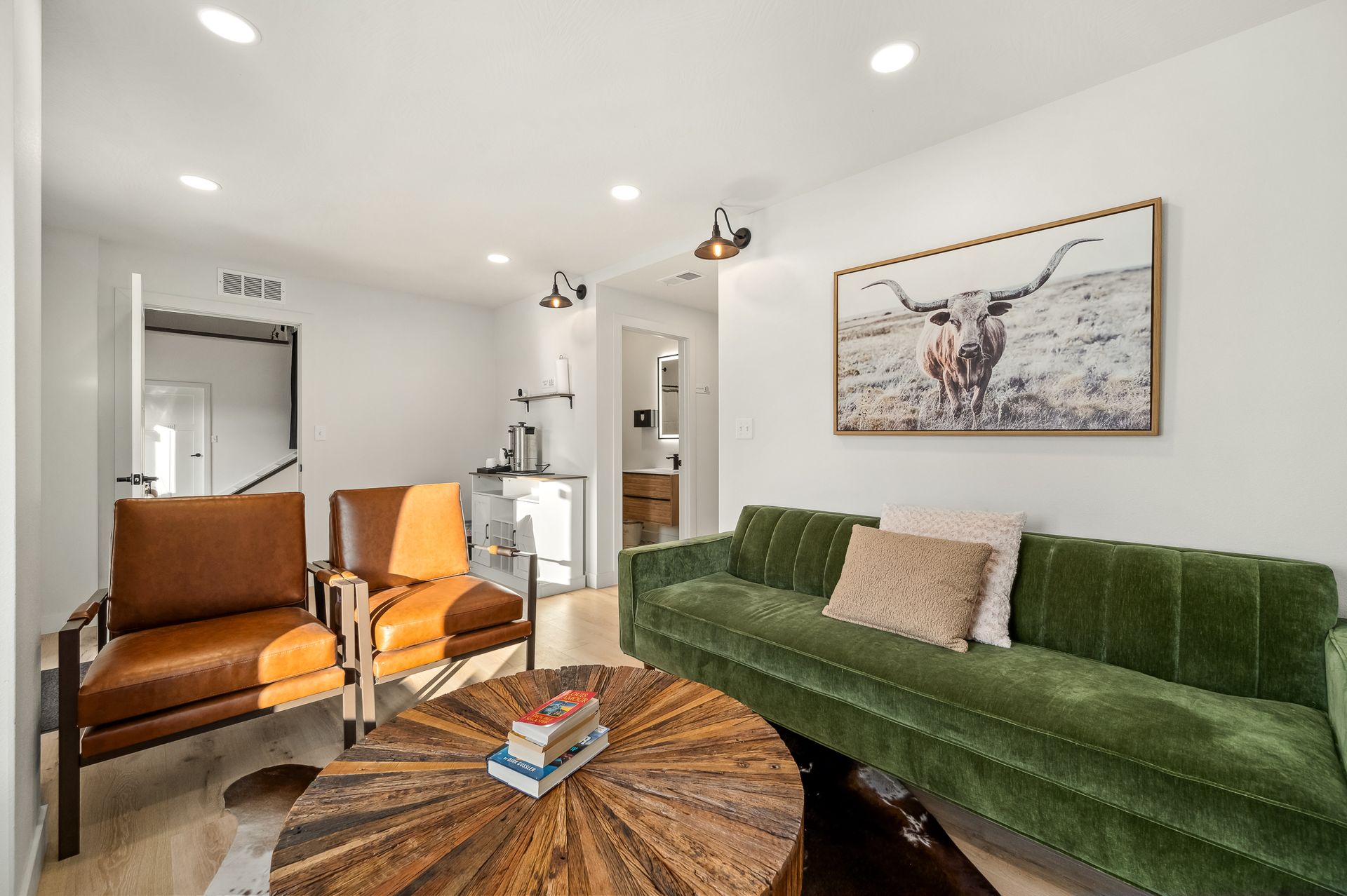 A living room with a green couch , two chairs , and a wooden coffee table.