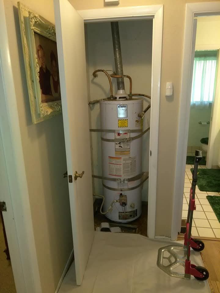 Water heater in a closet with a partially open door, dolly in the foreground.
