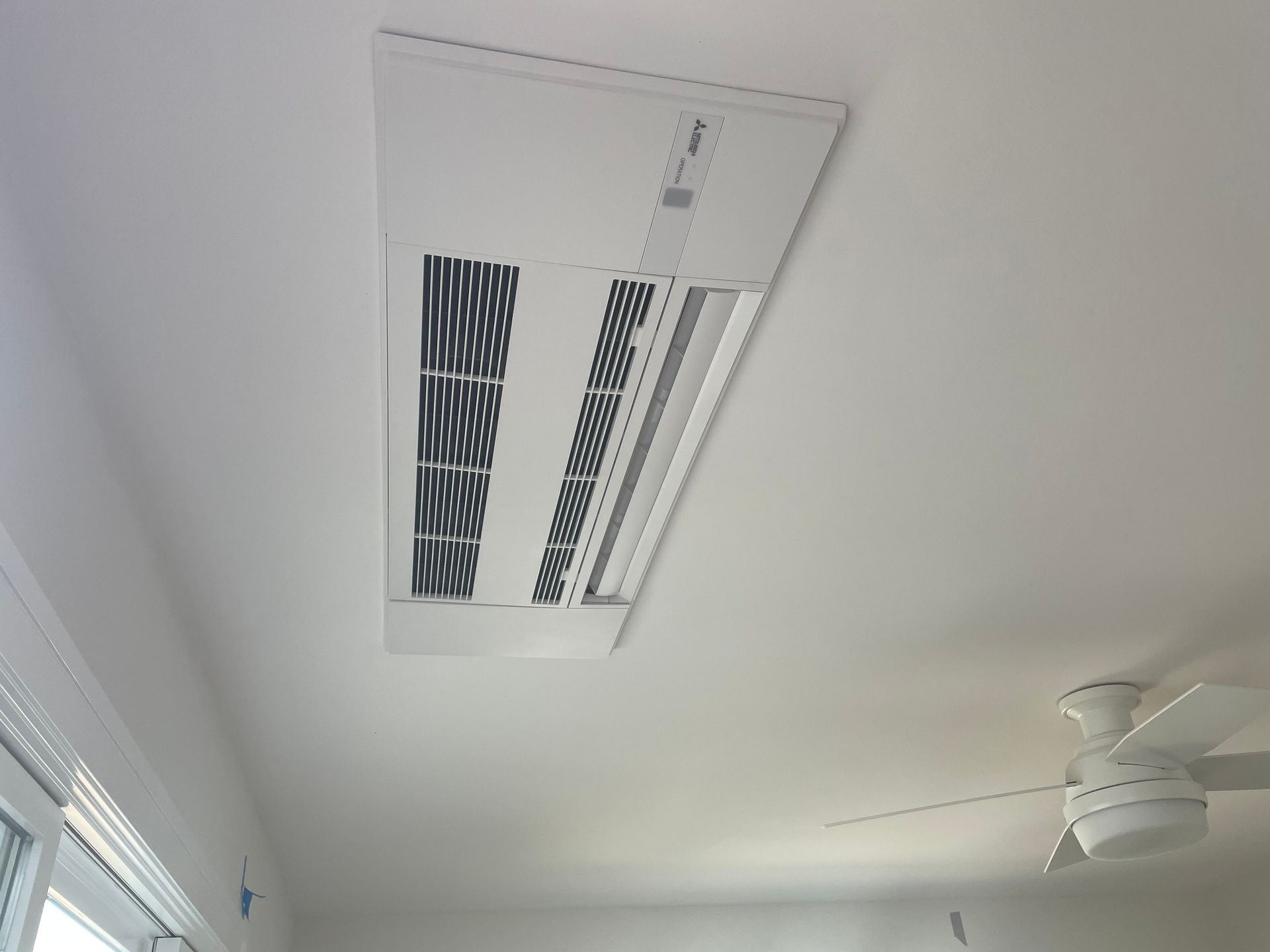 Ceiling vent and white ceiling fan in a bright room