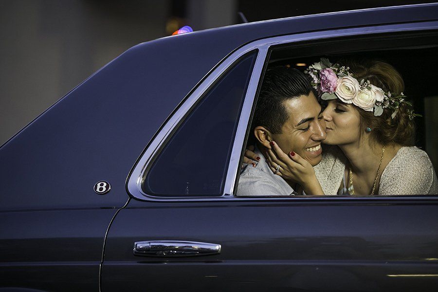 A man and a woman are kissing in a car.
