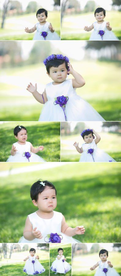A baby girl is wearing a white dress and a purple flower crown.