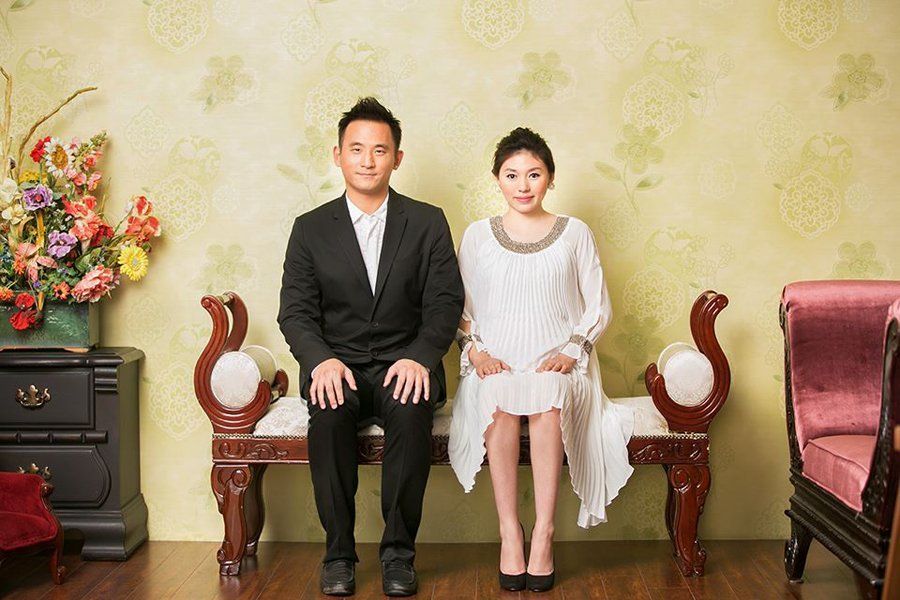 A man and a woman are sitting on a bench in a living room.