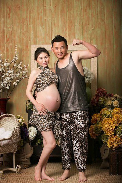 A man and a pregnant woman are posing for a picture.