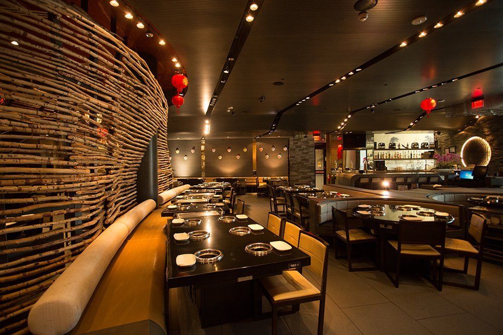 A restaurant with tables and chairs and a wicker wall