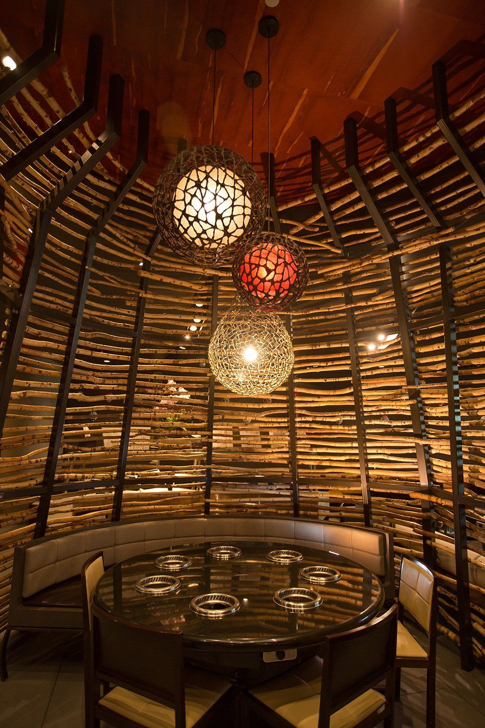 A dining room with a round table and chairs and a wooden wall.