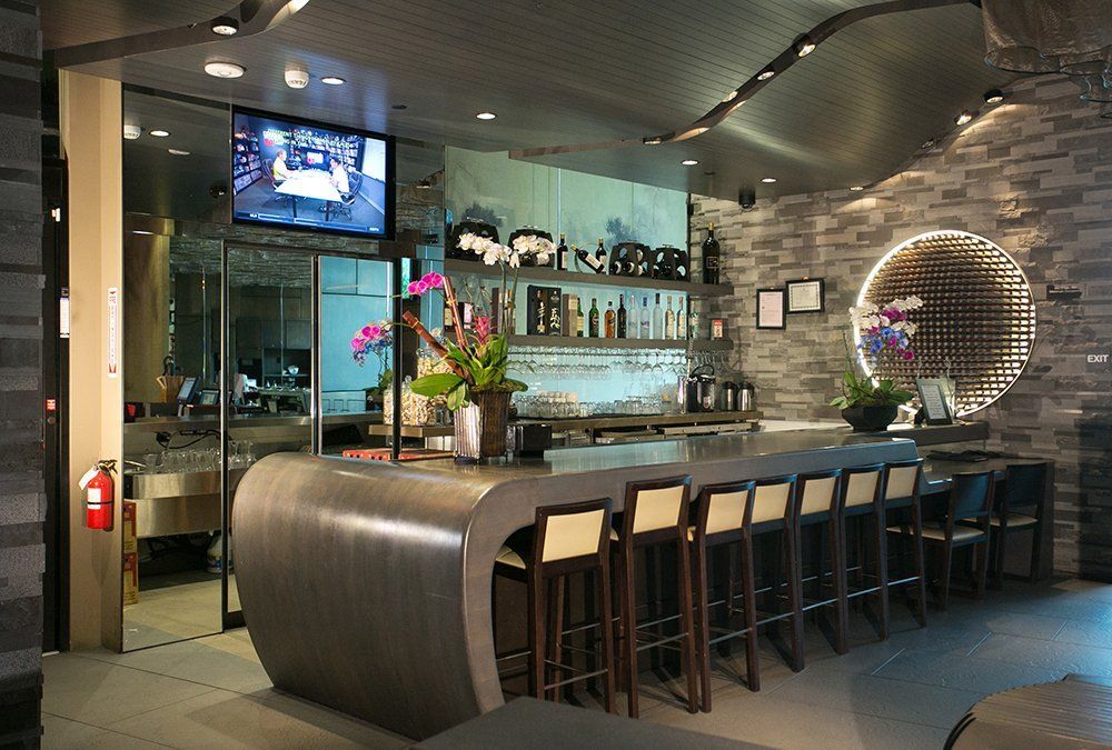 A restaurant with a long bar and stools