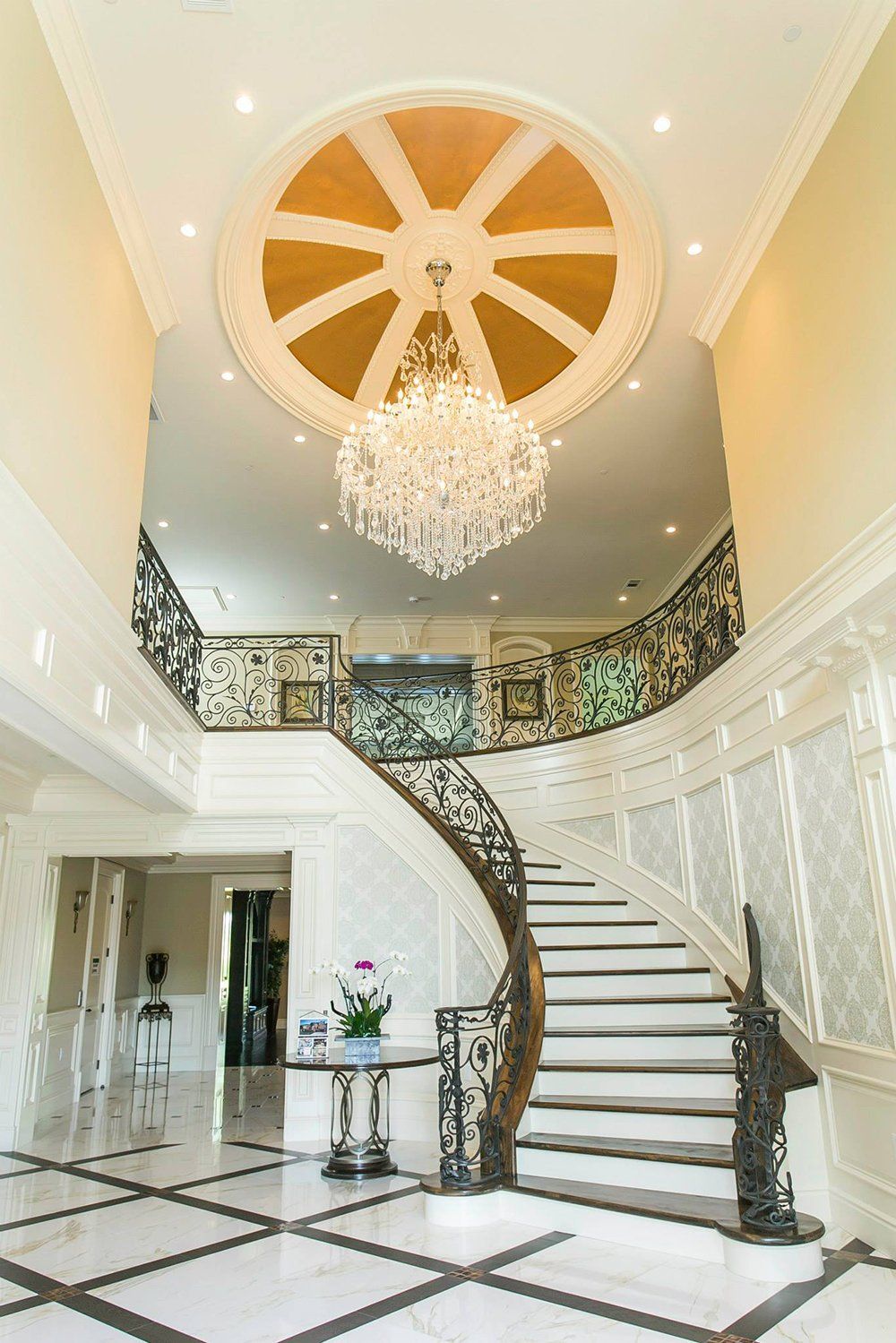 A large staircase with a chandelier hanging from the ceiling.