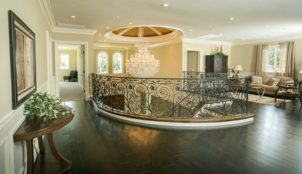 A large living room with a curved staircase and a chandelier