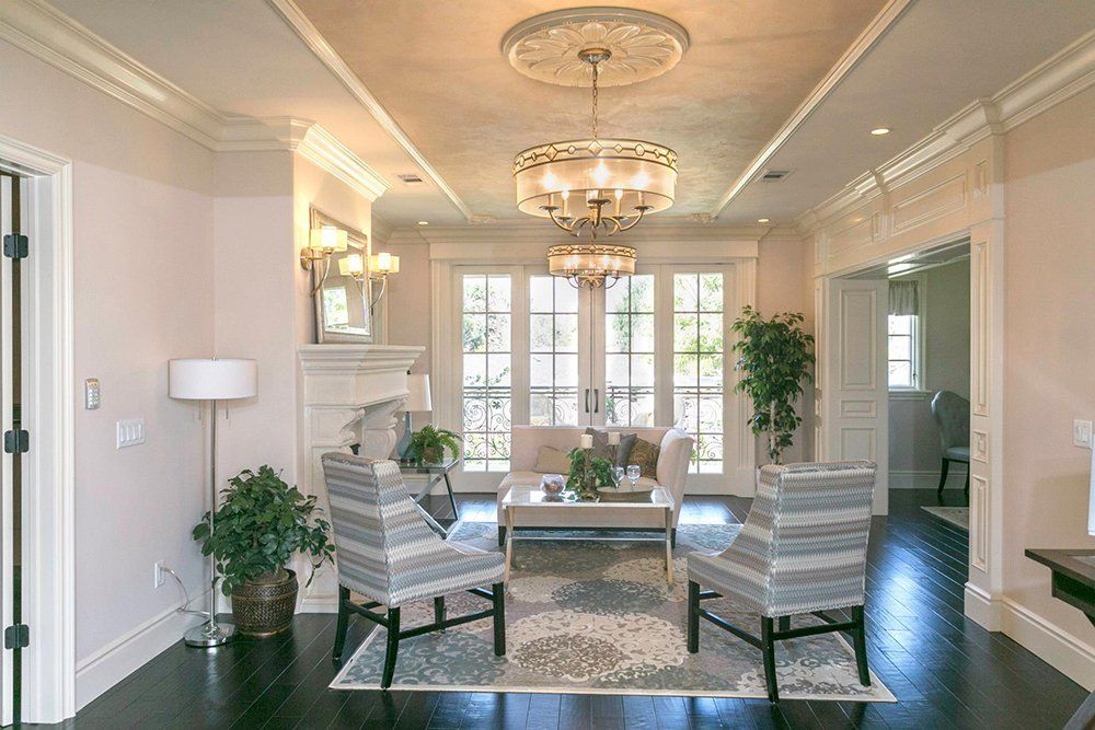 A living room with a couch , chairs , and a chandelier.