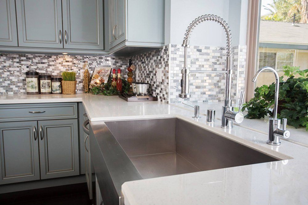 A kitchen with a large stainless steel sink and a faucet.