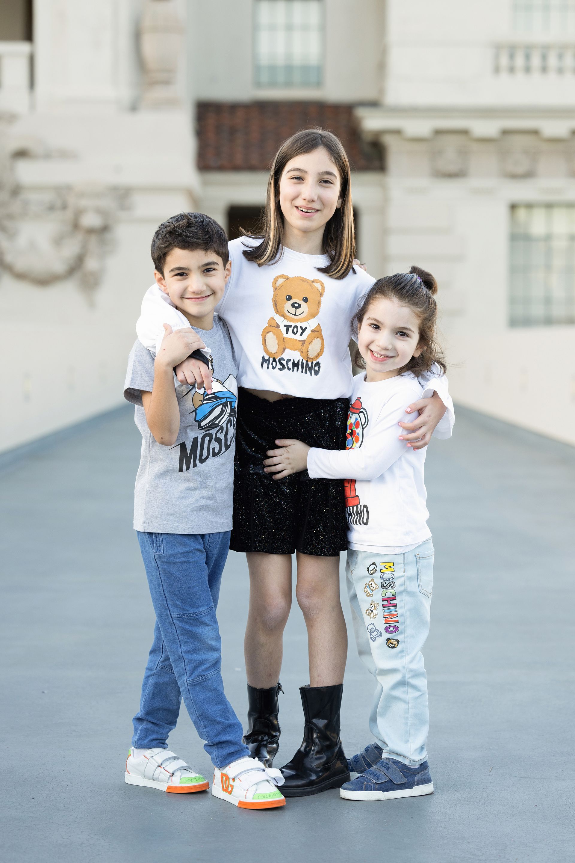 Have one family member stand behind the other two, wrapping their arms around everyone from the back. Capture everyone laughing or looking at each other, emphasizing a spontaneous and joyful connection.