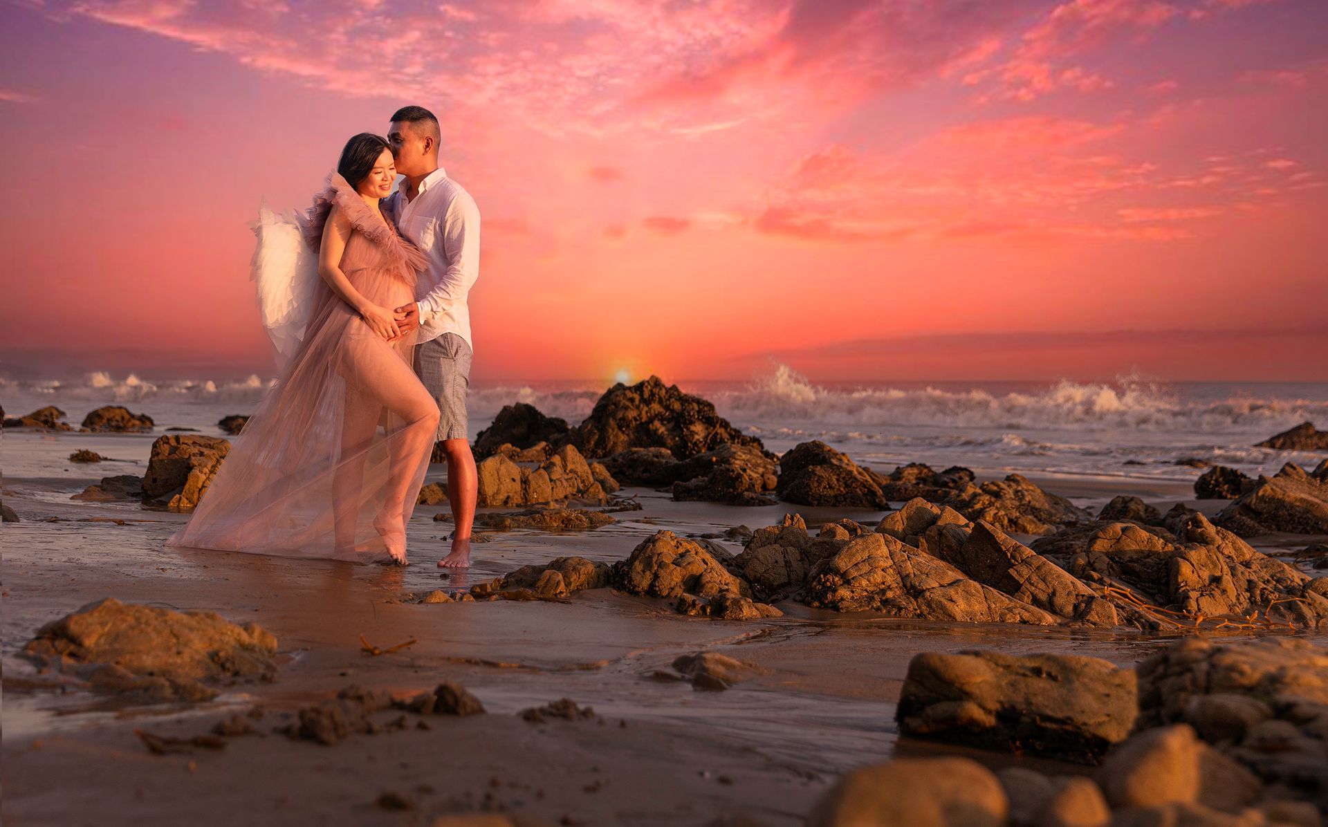 maternity woman is standing on malibu beach