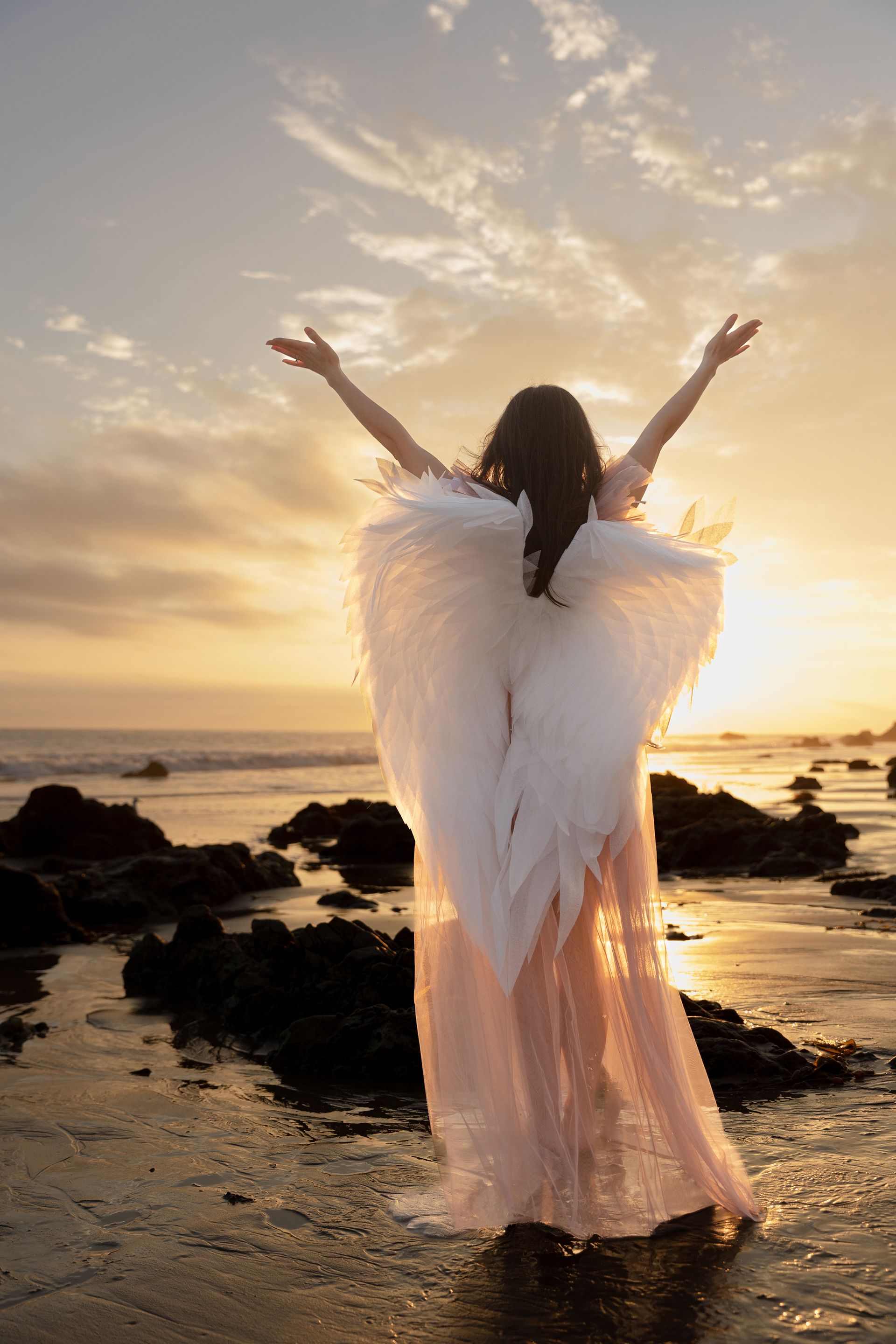 lady with angel wing  on California beach 