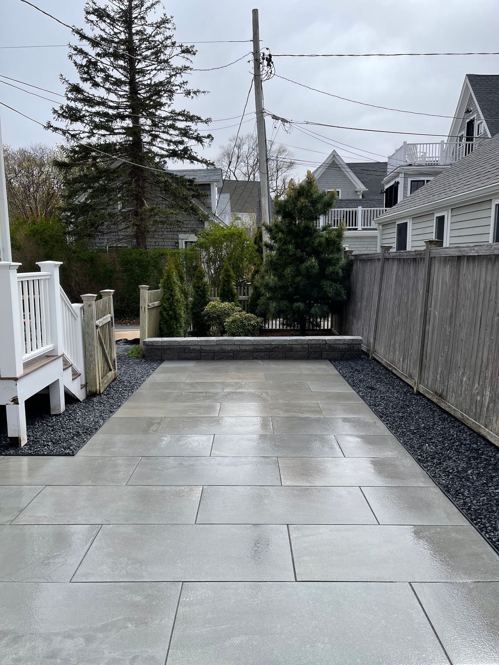 A concrete walkway leading to a house on a cloudy day