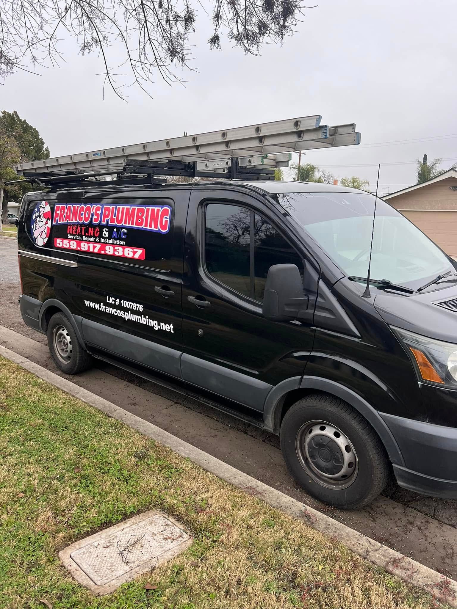 Black plumbing van parked curbside, with ladder on top. Business logo visible.