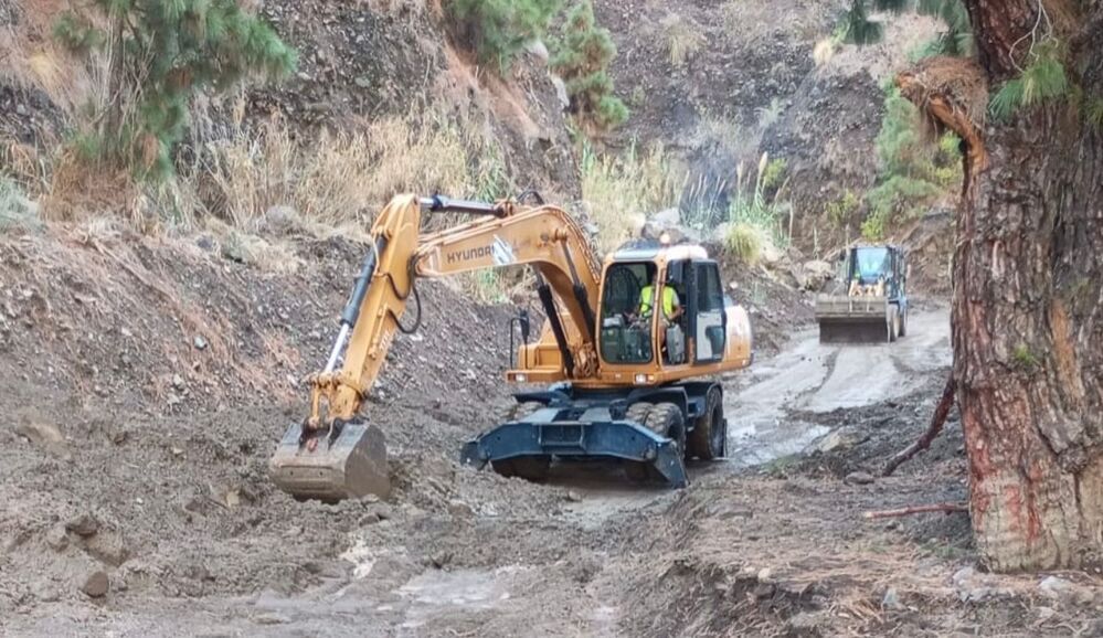 Torres de ràdio i petit edifici de pedra en un paisatge muntanyós, sota un cel ennuvolat.