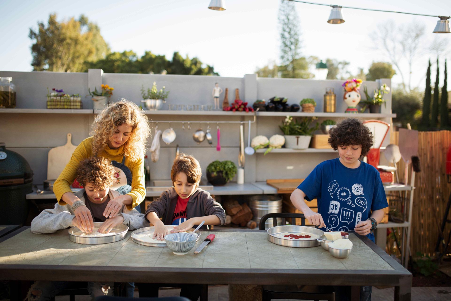 A Family Making Food Together At A Barbecue Island