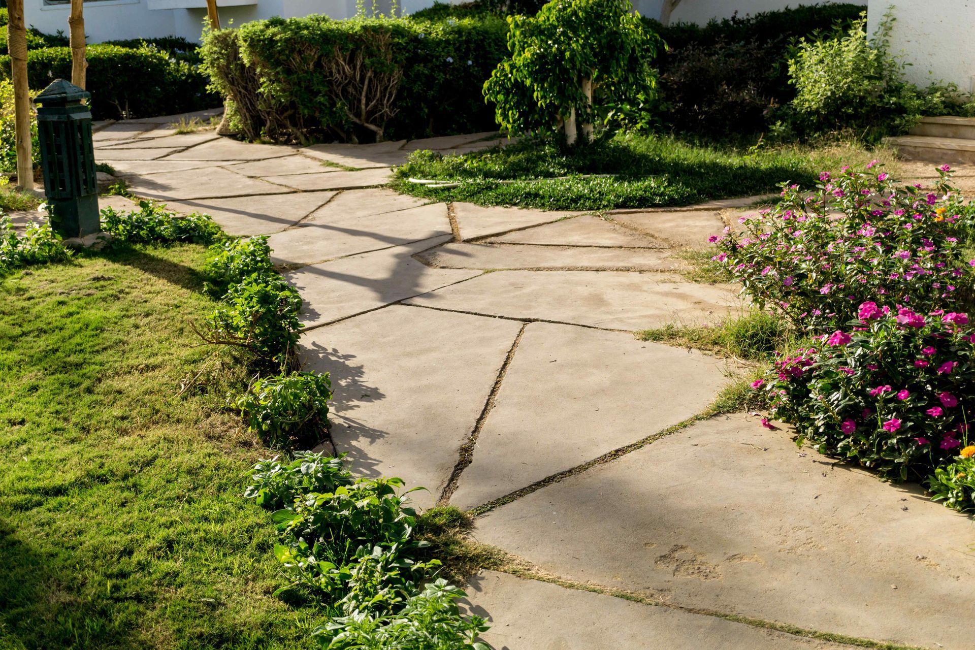 A complete paver pathway going by a garden