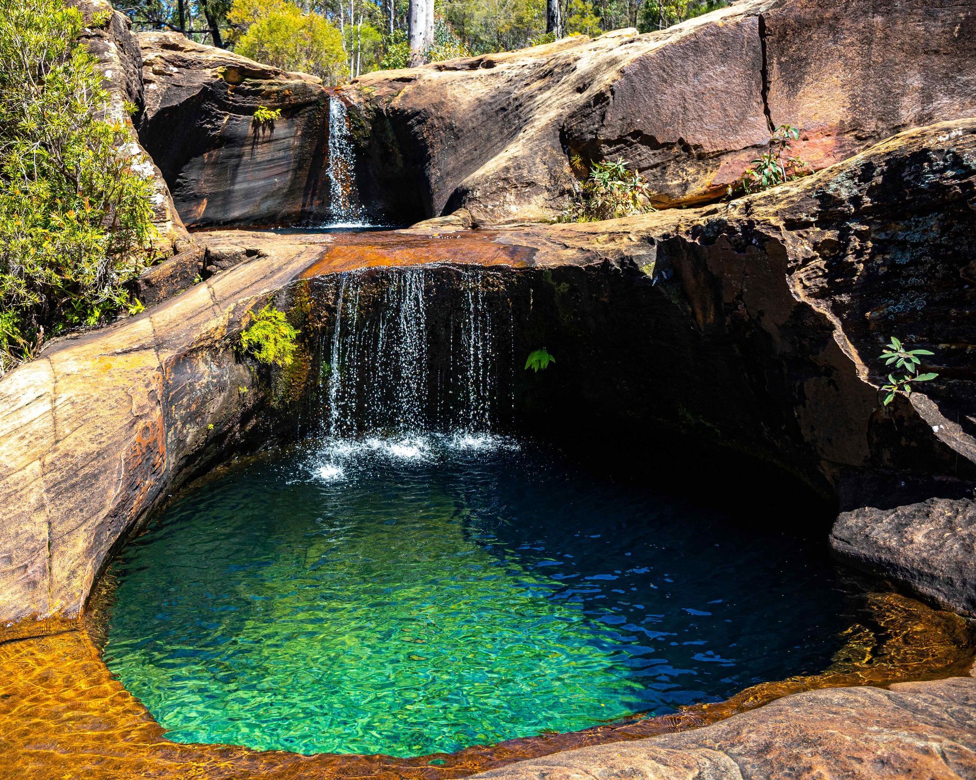 A Waterfall Flowing Into A Pool, This Water Feature Is Built Into The Landscape