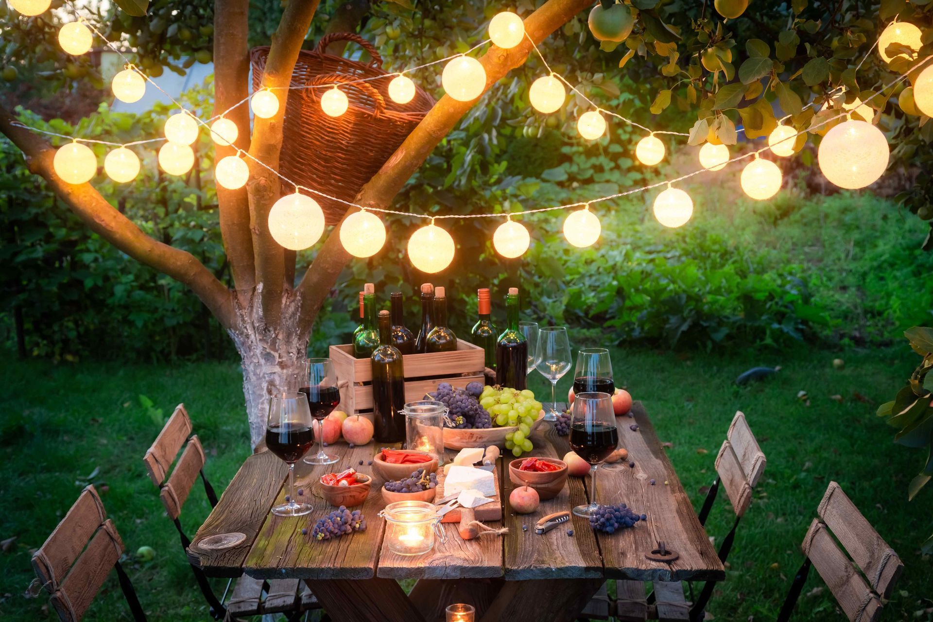 String lights over a picnic table filled with food