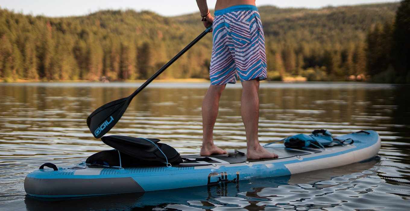 Man standing on blue paddleboard