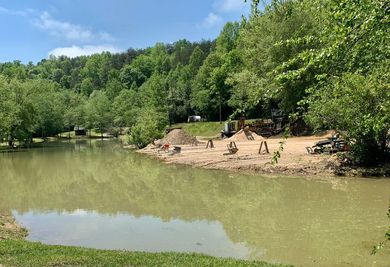 A large body of water surrounded by trees on a sunny day.