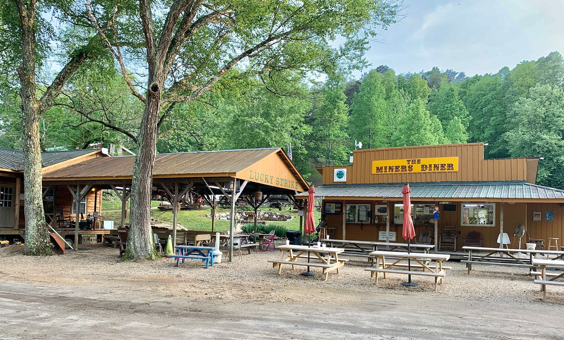 A picnic area in front of a building with a sign that says ' the muddy moose ' on it