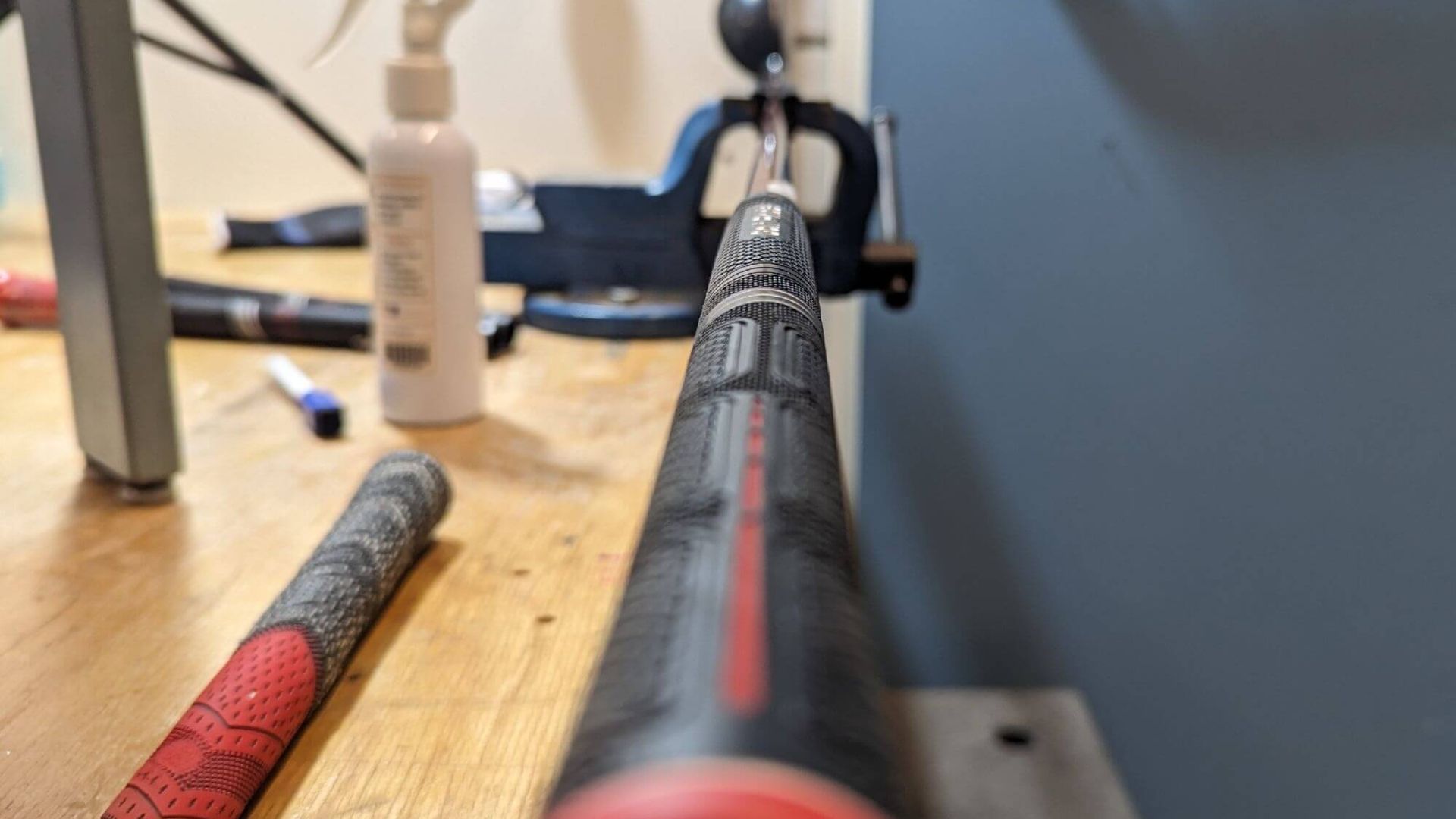 Hands gripping the textured black handle of a white mobility cane against a black background.
