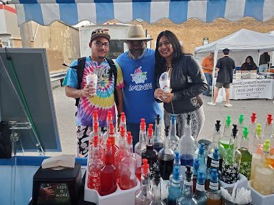 A group of people are standing in front of a display of bottles of alcohol.