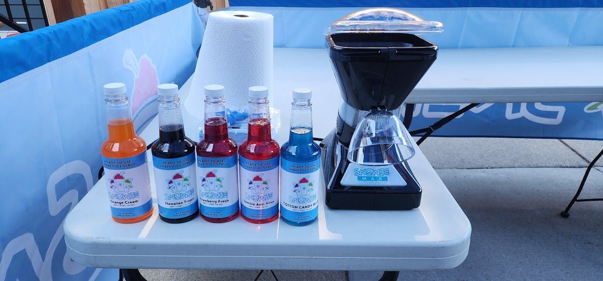 A table with bottles of ice cream and a blender on it.