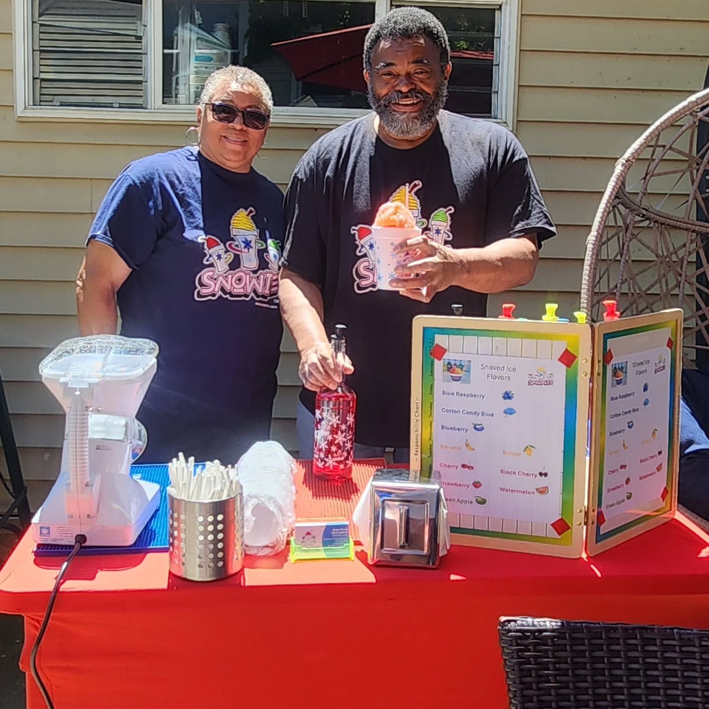 A man and a woman are standing next to each other at a table.