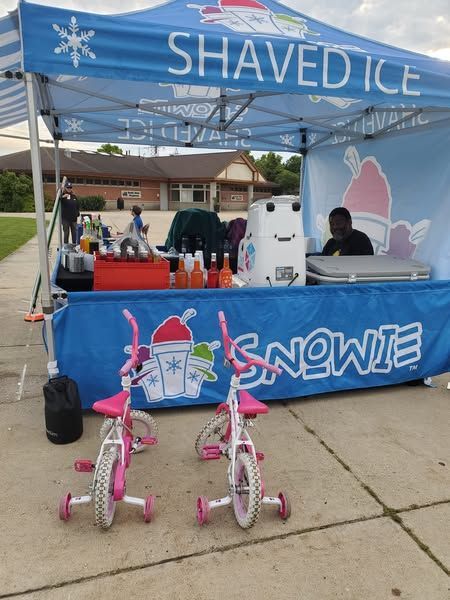 A shaved ice stand with two pink bikes in front of it