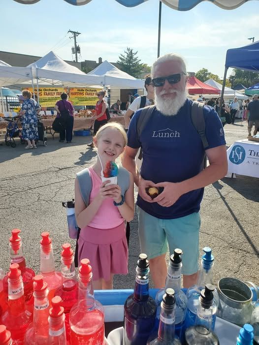 A man and a little girl are standing next to each other at a market.