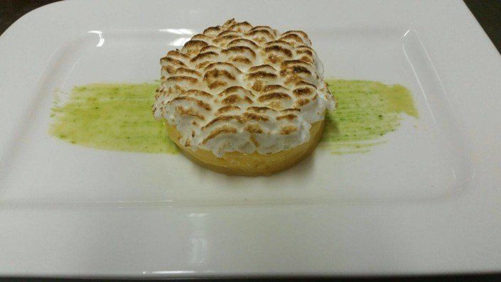 Ein Dessert auf einem weißen Teller mit einer grünen Sauce